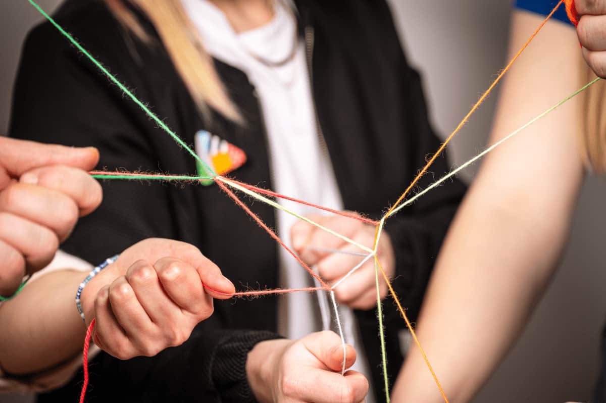 format:c spinnt Fäden – kreativ Das Team von format:c hält verschiedene Fäden in der Hand und suggeriert so, dass alle an einem Strang ziehen